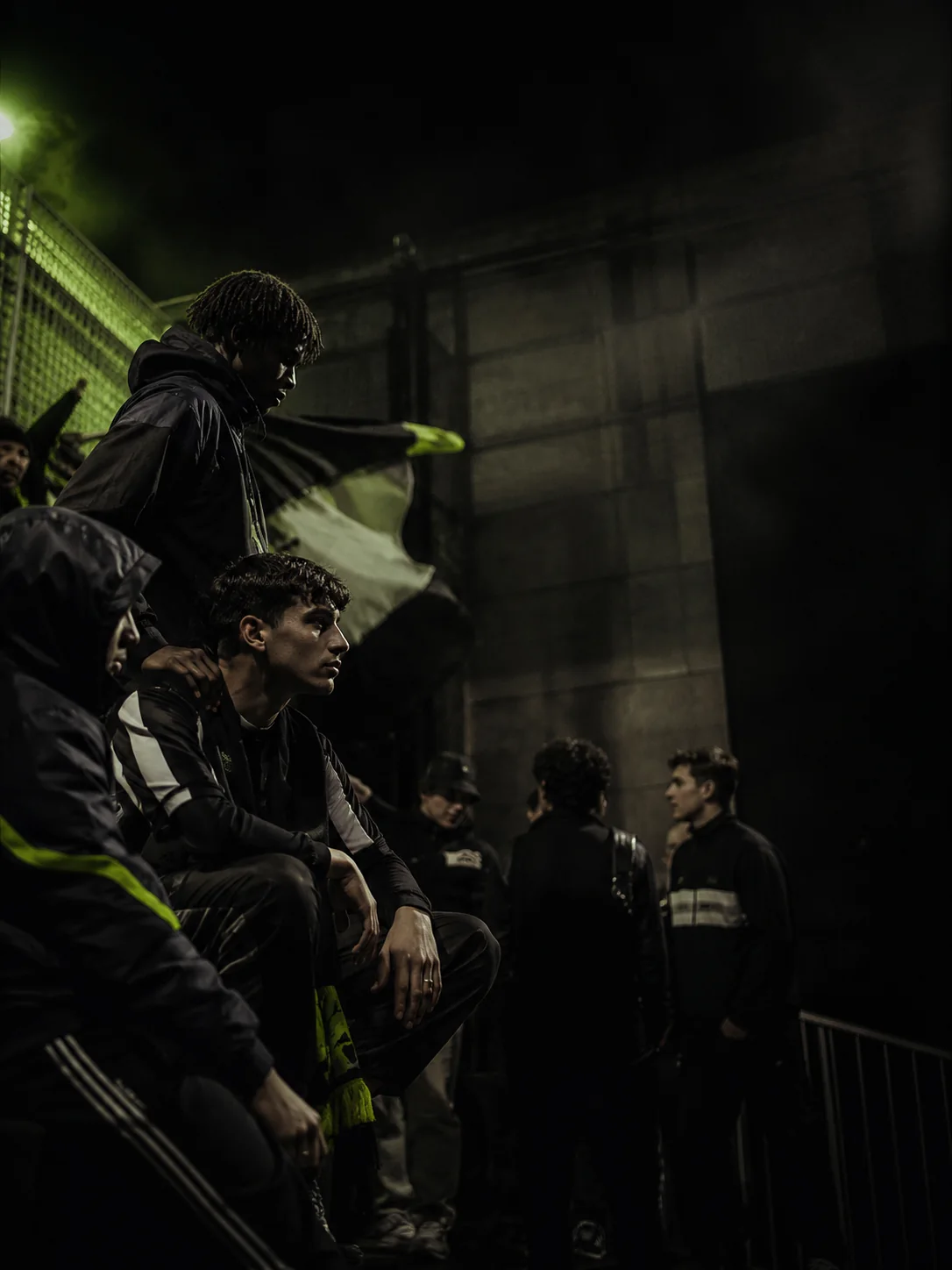 Nightweeds terrace culture portrait in a dark football environment.